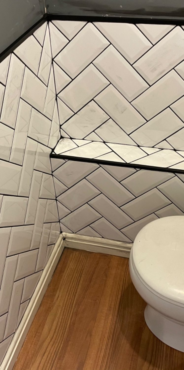 Herringbone tile with white ceramic with black grout.