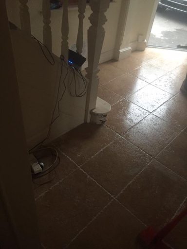 Staircase with a tiled floor and cables near the wall.