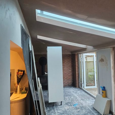 Interior of a partially renovated room with skylights and construction materials. Plastered and boarded in kidderminster by fis finishes